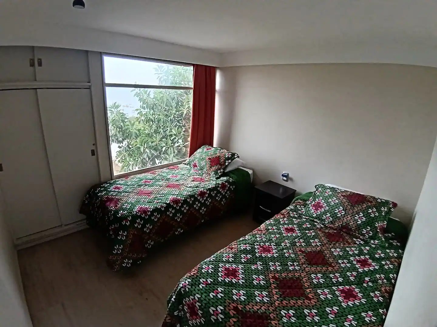 Habitación con dos camas singles y ventanal luminoso